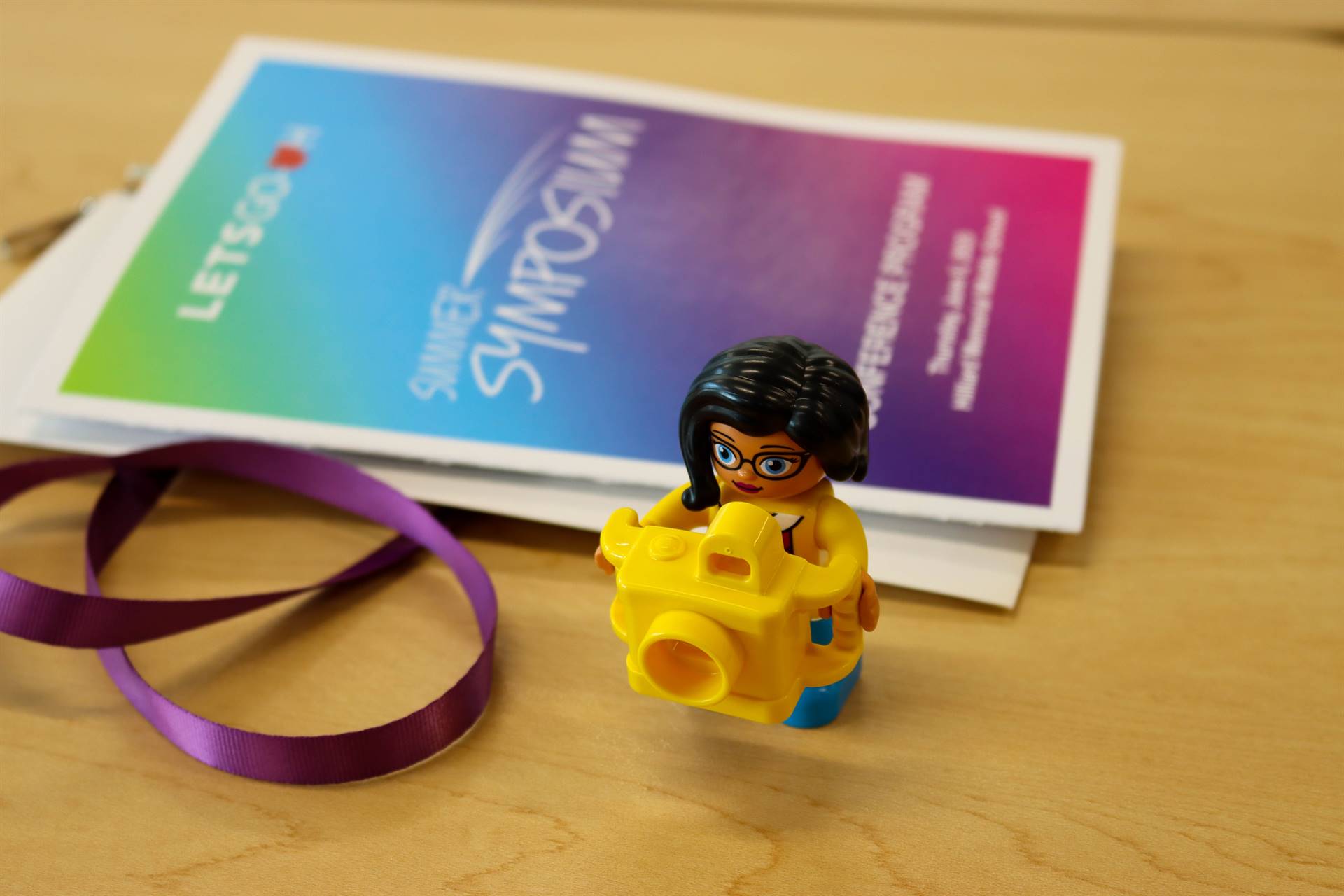 LETS GO OHIO Summer Symposium session schedule pamphlet and lego holding a camera